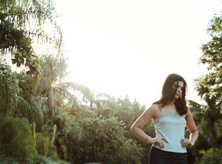 Woman standing outdoors with hands on hips