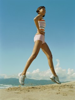 Mixed race woman exercising on beach