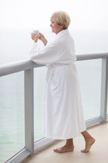 Older Caucasian woman drinking coffee on balcony