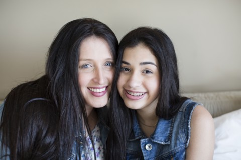 Hispanic mother and daughter smiling