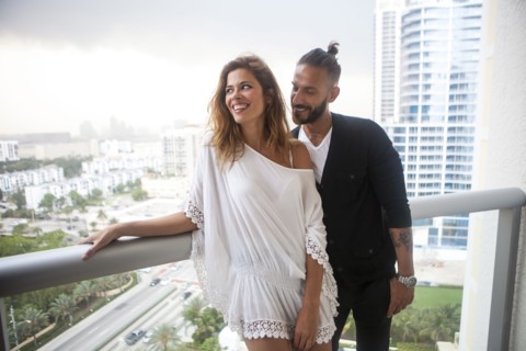 Hispanic couple standing on urban balcony