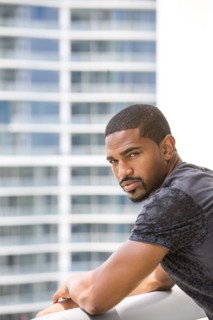 African American man standing on urban balcony