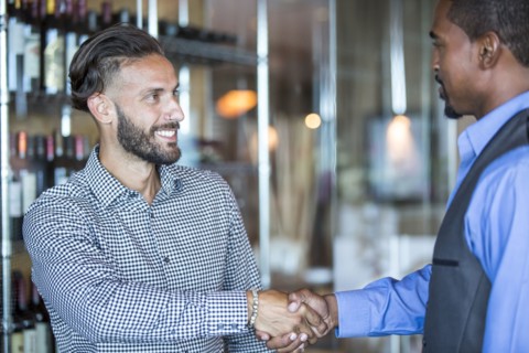 Businessmen shaking hands in restaurant