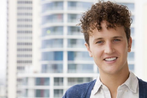 Caucasian man smiling on urban balcony
