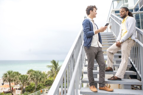 Businessmen talking on steps over urban beach
