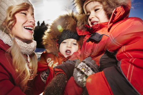 Mother and sons laughing outdoors