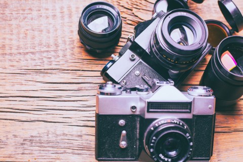 Cameras and lenses on wooden table