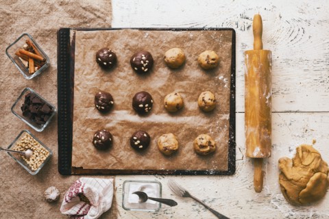 Cookie dough on baking sheet near rolling pin and ingredients