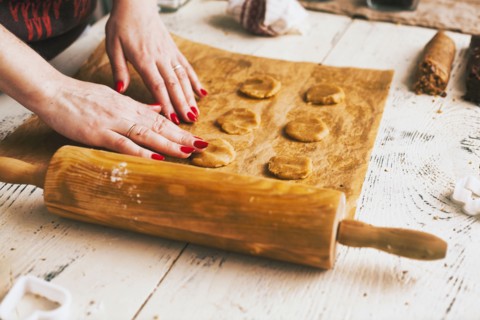 Hands of woman pressing cookie dough on baking sheet