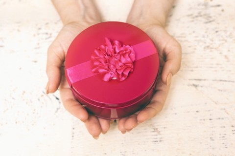 Hands of woman holding round gift box