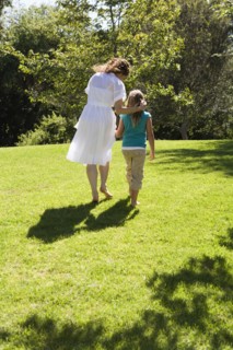 Mother and daughter walking together in grass