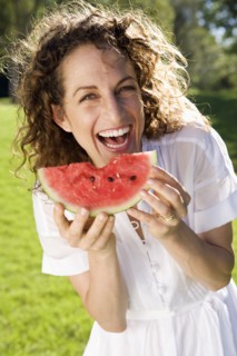Smiling woman eating watermelon