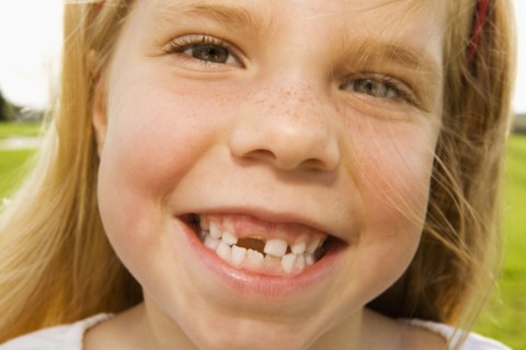 Grinning girl with tooth missing