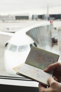 Caucasian man looking at passport in airport