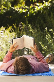 Caucasian teenager reading outdoors