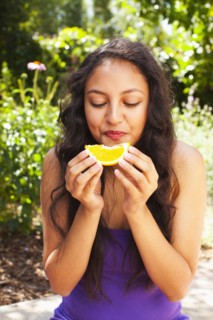 Mixed race teenager eating orange
