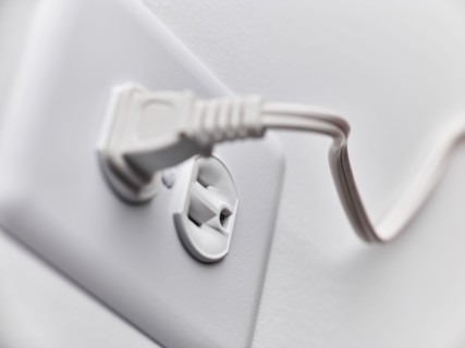 Close up of white plug in outlet