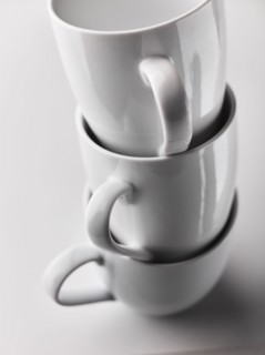 Close up of stacked white mugs