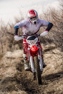 Motorcyclist riding dirt bike on rural path