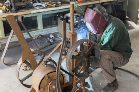 Artist welding steel in workshop