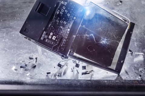 Laptop falling and shattering on desk