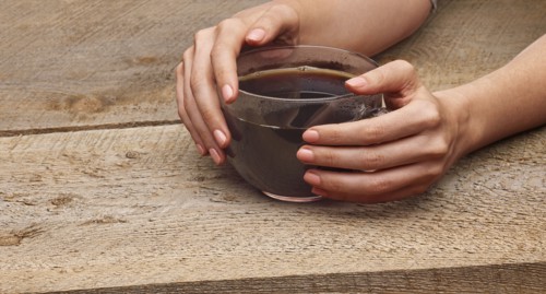 Hands of woman holding coffee cup