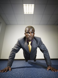 Black businessman doing push-ups