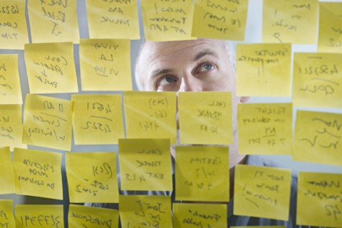 Caucasian businessman looking at adhesive notes on wall