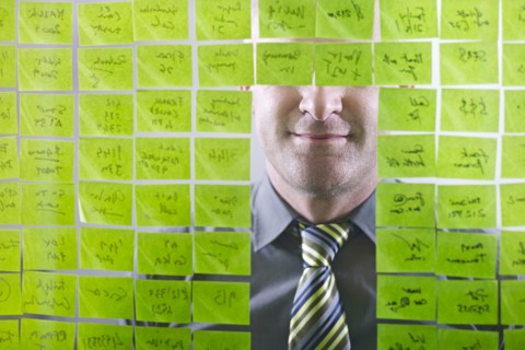 Caucasian businessman looking at adhesive notes on wall