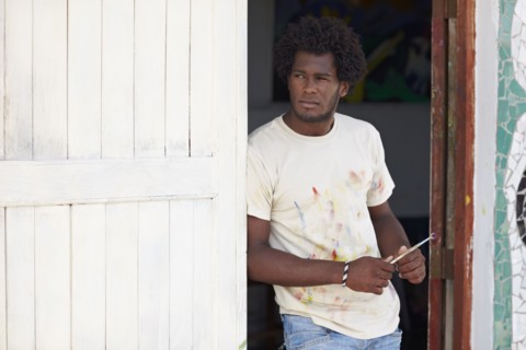 Black artist leaning in doorway