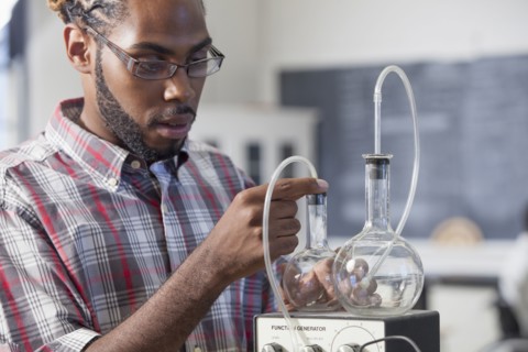 Student performing experiment in science classroom