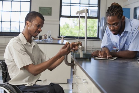 Paraplegic student and classmate working in science classroom