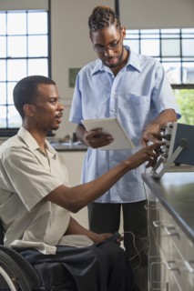 Paraplegic student and classmate working in science classroom