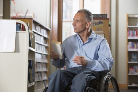 Caucasian man holding book in library