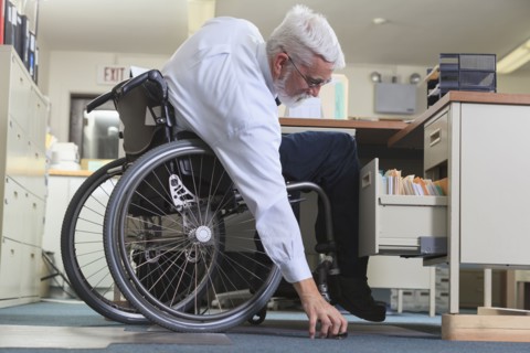 Caucasian businessman picking up object on floor