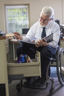 Caucasian businessman reading binder at desk