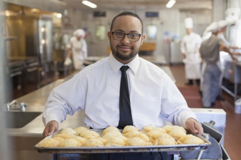 Mixed race chef with down syndrome cooking in restaurant