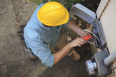 Caucasian worker installing cable box