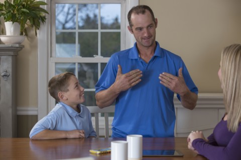 Caucasian family signing at dinner table
