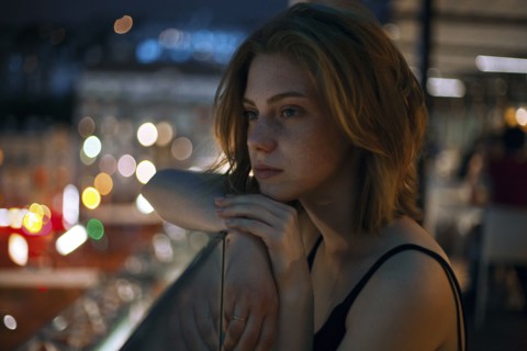 Pensive Caucasian teenage girl leaning on railing