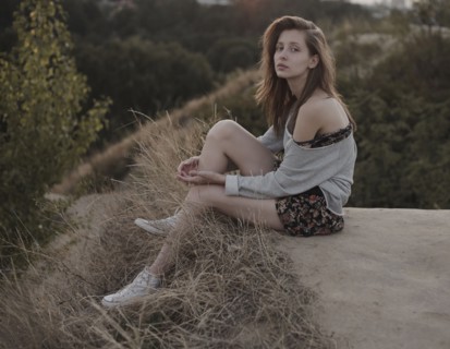 Serious Caucasian woman sitting on hill