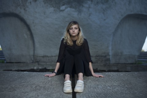 Portrait of serious Caucasian woman sitting on concrete