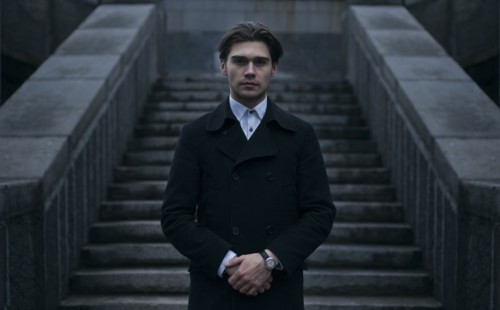 Portrait of serious Caucasian man standing near staircase