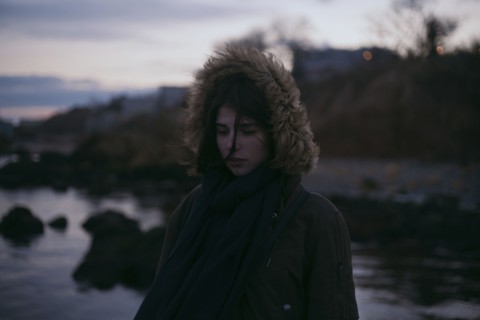 Caucasian woman wearing fur hood at ocean