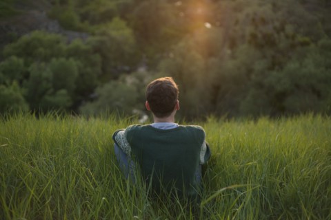 Caucasian man sitting in grass