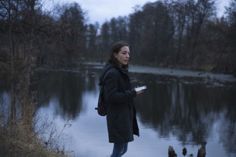 Caucasian woman holding cell phone near river