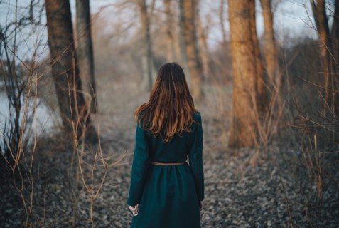 Caucasian woman standing near trees and river