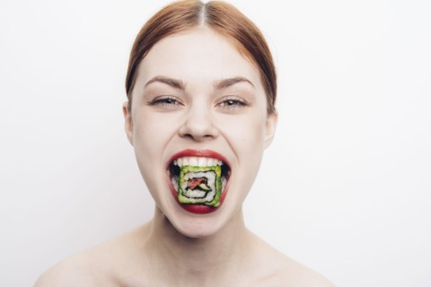 Caucasian woman with mouthful of sushi