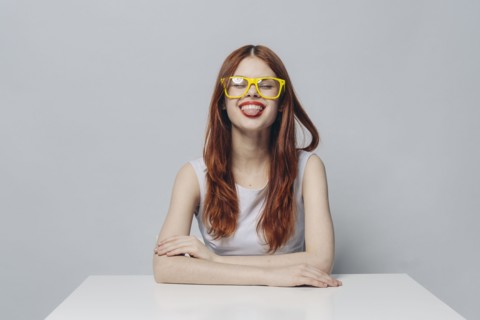 Caucasian woman sitting at table with tongue out