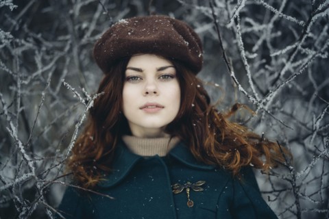Serious Caucasian woman near icy branches